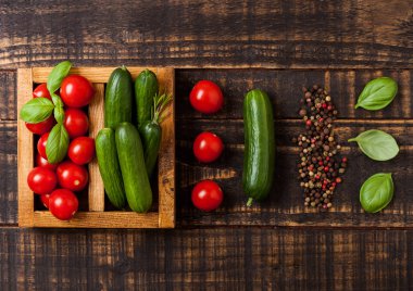 Organik domates ve salatalık ahşap masa vintage ahşap kutusunda fesleğen ve keten havlu ile