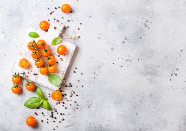 Organik portakal Rapture domates fesleğen ve taş zemin üzerine kıyma kurulu üzerinde biber ile asma üzerinde.