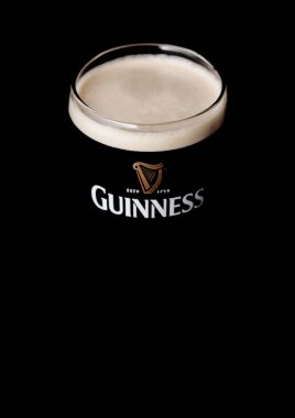 Londra, İngiltere - 27 Nisan 2018: Orijinal bardak Guinness fıçı şişman bira siyah arka plan üzerine. Guinness bira Dublin, İrlanda 1759 yılından bu yana üretilen.