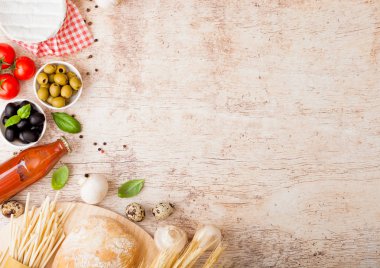 Ev yapımı makarna makarna ile bıldırcın yumurtası ile şişe domates sos ve peynir ahşap arka plan üzerinde. Klasik İtalyan köyü gıda. Sarımsak, petrol, siyah ve yeşil zeytin, yağ ve ekmek.