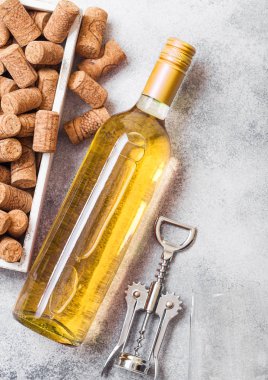 Şişe ve bardak beyaz şarap mantarlar ve crkscrew açacağı taş mutfak üzerinde kutu ile arka plan masa. Üstten görünüm. 