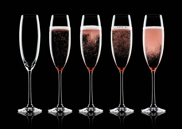 Rose pink champagne glasses with bubbles on black background with reflection