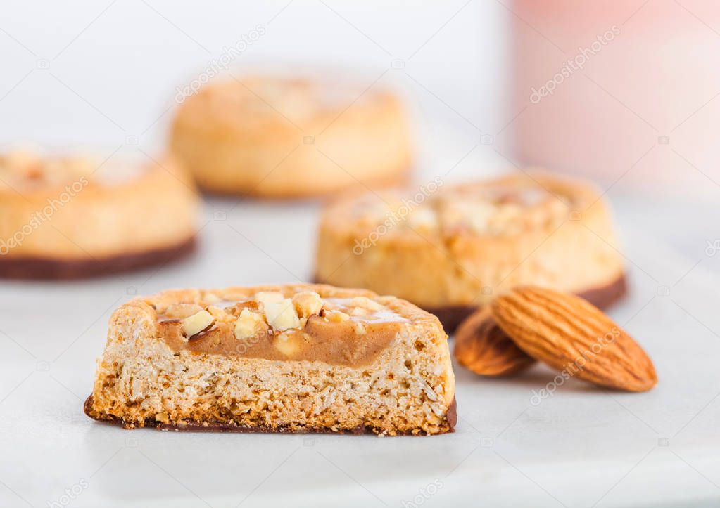 Homemade biscuit cookies with almond nuts and peanut butter on marble coasters on kitchen table background.