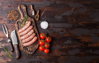 Ham sığır eti ve domuz sosis vintage bıçak ve çatal ahşap arka plan üzerinde eski kesme tahtası üzerinde. Tuz ve karabiber biberiye ile.