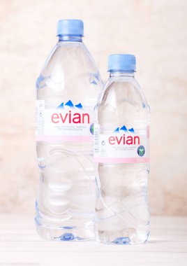 Londra, İngiltere - 03 Eylül 2018: Plastik şişe Evian doğal maden suyu bir ahşap üzerine. Fransa'da yapılan
