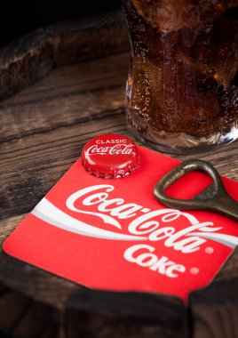Londra, İngiltere - 10 Ağustos 2018: Coaster özgün Coca Cola meşrubat şişe üst ve açacağı ve ahşap varil üzerine özgün cam.