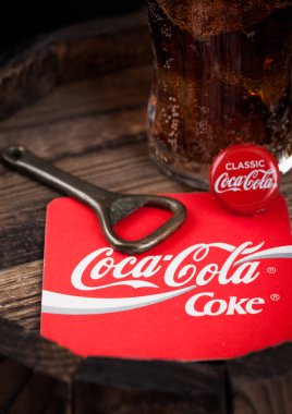 Londra, İngiltere - 10 Ağustos 2018: Coaster özgün Coca Cola meşrubat şişe üst ve açacağı ve ahşap varil üzerine özgün cam.