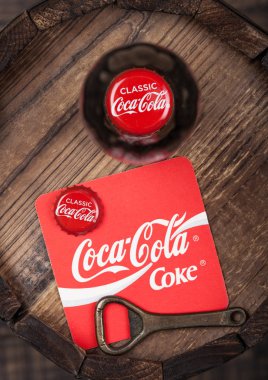 Londra, İngiltere - 10 Ağustos 2018: Coaster özgün Coca Cola meşrubat şişe üst ve açacağı ve ahşap varil üstüne şişe.