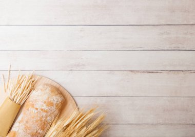 Taze ev yapımı İtalyan ekmeği ile Ham buğday ve spagetti ahşap arka plan üzerinde.