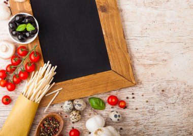 Ev yapımı makarna makarna bıldırcın yumurtası ve kömür menü Yönetim Kurulu ve ahşap zemin üzerine peynir ile. Klasik İtalyan köyü gıda. Sarımsak, petrol, siyah ve yeşil zeytin, tahta spatula.