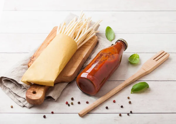 Fresh organic homemade spaghetti pasta with bottle of tomato sauce and wooden spatula and basil leaf on wooden board background.