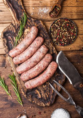 Ham sığır eti ve domuz sosis vintage bıçak ve çatal ahşap arka plan üzerinde eski kesme tahtası üzerinde. Tuz ve biber.