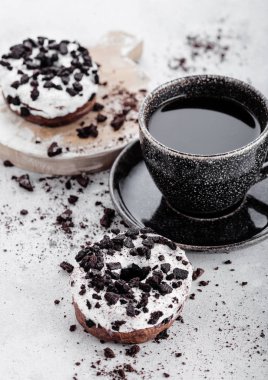 Siyah kahve fincanı tabağı ve çörek taş mutfak masa arka plan üzerinde siyah kurabiyeyle ile.