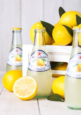 Londra, İngiltere - 15 Ocak 2019: Cam San Pellegrino köpüklü, limon şişe soda İçecek beyaz kutu içinde taze limon ile ahşap arka plan üzerinde.