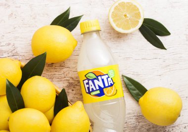 Londra, İngiltere - 15 Ocak 2019: Fanta Lemon meşrubat ahşap backgroundt üzerinde taze limon ile plastik şişe. Popüler meyve aromalı gazlı alkolsüz içecek Fanta olduğunu.