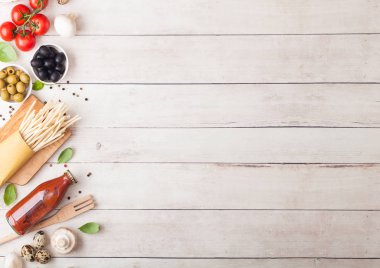 Ev yapımı makarna makarna ile bıldırcın yumurtası ile şişe domates sos ve peynir ahşap arka plan üzerinde. Klasik İtalyan köyü gıda. Sarımsak, petrol, siyah ve yeşil zeytin