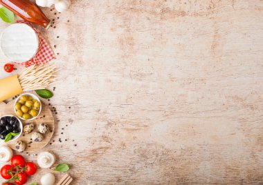 Bıldırcın yumurtalı, domates soslu ve ahşap kaplamalı ev yapımı makarna. Klasik İtalyan köy yemekleri işte. Sarımsak, şampiyon, siyah ve yeşil zeytin, yağ ve spatula.