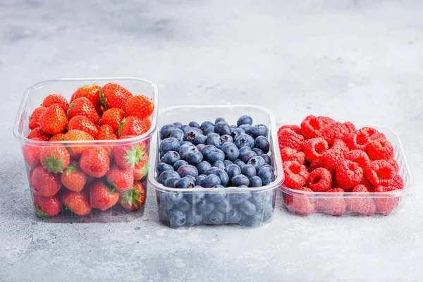 Plastikbehälter Mit Frischen Gesunden Bio Blaubeeren Erdbeeren Und Himbeeren Auf — Stockfoto