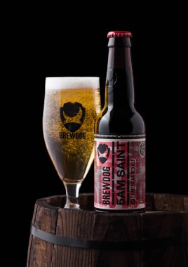 Londra, İngiltere - 06 Şubat 2019: Şişe ve bardak siyah arka plan üzerine eski ahşap varil üzerinde Brewdog bira üzerinden 5 am Saint Amerikan kırmızı bira bira.