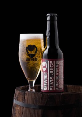 Londra, İngiltere - 06 Şubat 2019: Şişe ve bardak Elvis suyu greyfurt IPA biradan Brewdog bira siyah arka plan üzerine eski ahşap varil üzerinde.