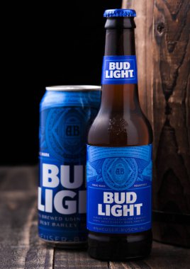 Londra, İngiltere - 06 Şubat 2019: Cam şişe ve alüminyum kutu Bud Light bira eski ahşap varil, ilk 1876 yılında tanıtılan bir Amerikan lager yanındaki.