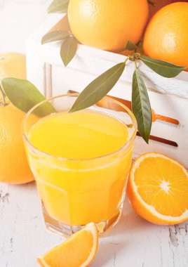 Beyaz ahşap kutusunda Ham portakal suyuyla organik taze turuncu smoothie bardak