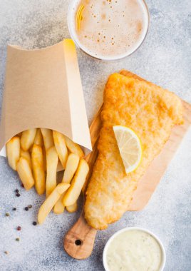 Geleneksel İngiliz balık ve cips tartar sosu abd cam el sanatları lager bira beyaz taş kesme tahtası üzerinde arka plan masa. Üstten Görünüm