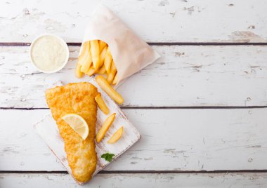 Geleneksel İngiliz balık ve patates kızartması ile Remoulade doğrama kurulu üzerinde üzerinde woode arka plan beyaz. Metin için yer