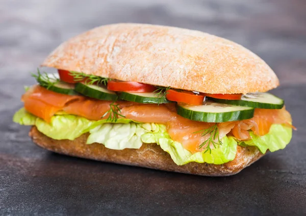 Friss egészséges lazac szendvics, saláta, uborka, fekete kő háttér. Reggeli snack. Diéta élelmiszer — Stock Fotó