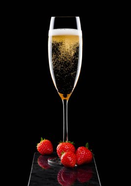 Zarif bardak taze stawberries siyah arka plan üzerine siyah mermer gemide ile sarı şampanya.