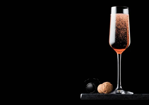 Elegante copo de champanhe rosa rosa com cortiça e gaiola de arame em placa de mármore preto no fundo preto. Espaço para texto — Fotografia de Stock