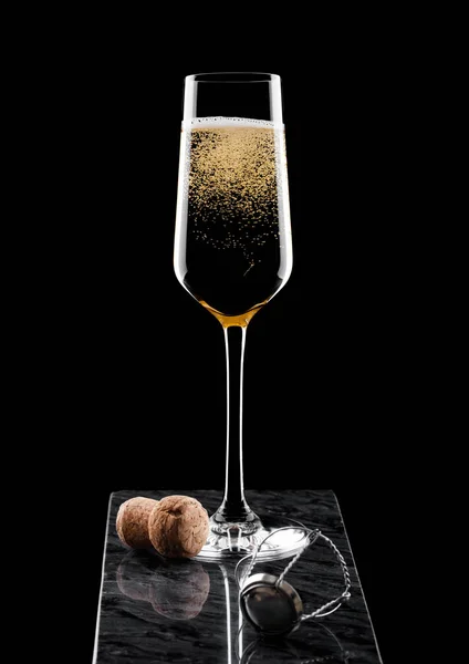 Elegante copa de champán amarillo con corcho y jaula de alambre sobre tablero de mármol negro sobre fondo negro. —  Fotos de Stock