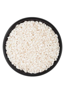 Black bowl of raw organic arborio risotto rice on white background. Healthy food.  clipart