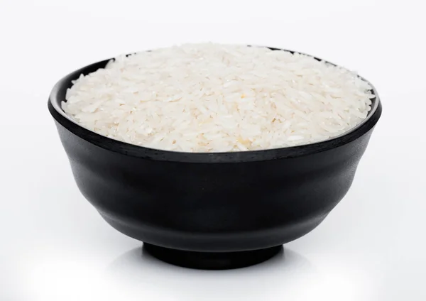 Tigela preta de arroz Basmati orgânico cru sobre fundo branco. Alimentos saudáveis . — Fotografia de Stock