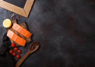 Taze Çiğ somon dilimi Kıyma Kurulu petrol domates ve limon ile taş mutfak masa arka plan üzerinde üzerinde. Metin için yer. İle boş yazı tahtası.