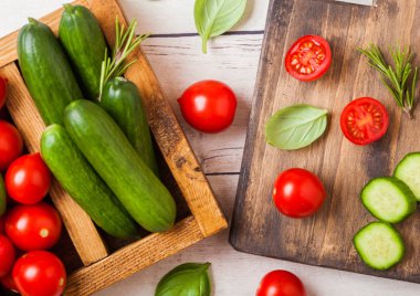 Organik domates ve salatalık Ahşap mutfak masasında vintage ahşap kutusunda fesleğen ve keten havlu ile