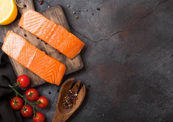 Taze Çiğ somon dilimi Kıyma Kurulu biber domates ve limon ile taş mutfak masa arka plan üzerinde. Metin için yer. Biberiye ve tuz ile