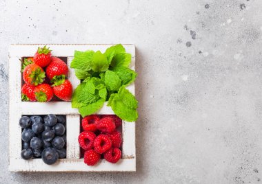 Mutfak Masa arka planda beyaz Vintage ahşap kutu taze ham organik çilek. Metin alanı. Üst görünüm. Çilek, ahududu, yaban mersini ve nane yaprağı