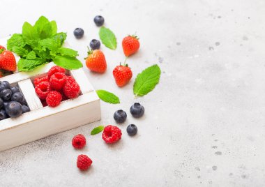 Taze ham organik çilek mutfak masası arka plan üzerinde beyaz ahşap kutu izole. Metin için boşluk. Üst te. Çilek, Ahududu, Yaban Mersini ve Nane yaprağı