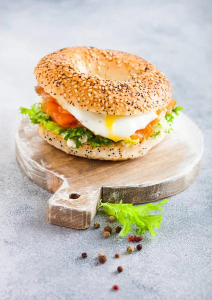 Sanduíche de bagel saudável fresco com salmão, ricota e ovo macio na tábua de corte vintage no fundo da mesa da cozinha branca. Alimentação saudável . — Fotografia de Stock