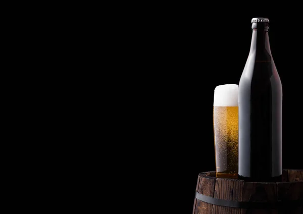Холодна пляшка і келих крафтового пива на старому бочці — стокове фото