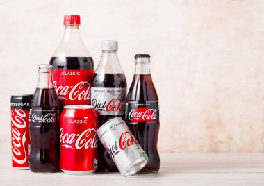 Londra, İngiltere - 03 Ağustos 2018: Ahşap zeminüzerinde Orijinal Coca Cola, Diyet Kola ve Zero alüminyum renkli plastik ve cam şişeler. Dünyanın en popüler içkisi.