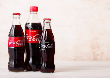 Londra, İngiltere - 03 Ağustos 2018: Ahşap arka planda orijinal Coca Cola meşrubat plastik ve cam şişe. Dünyanın en popüler içkisi.