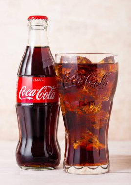 Londra, İngiltere - 03 Ağustos 2018: Ahşap arka planda cam şişe ve orijinal cam Orijinal Coca Cola meşrubat. Dünyanın en popüler içkisi.