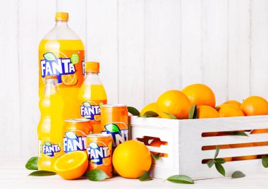 Londra, İngiltere - 31 Mart 2018: Plastik şişe ve Fanta portakal alkolsüz içecek Beyaz ahşap zemin üzerinde alüminyum teneke 