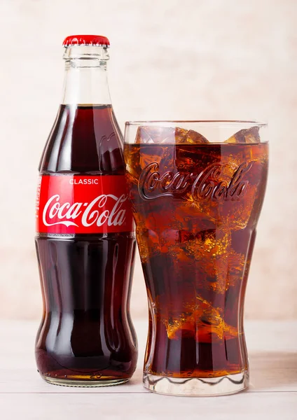 Londen, UK-augustus 03, 2018: glazen fles en origineel glas van originele Coca Cola frisdrank op houten achtergrond. Meest populaire drank ter wereld. — Stockfoto