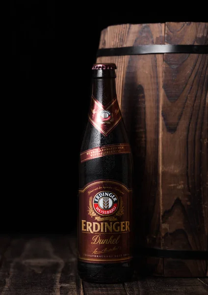 LONDRES, ROYAUME-UNI - 28 JUILLET 2018 : Bouteille de bière Erdinger Dunkel à côté d'un fût de bois Erdinger est le produit de la plus grande brasserie de bière de blé au monde . — Photo