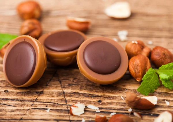 stock image Box of homemade candies on wooden background with mint and nuts. A hazelnut in Caramel and chocolate.