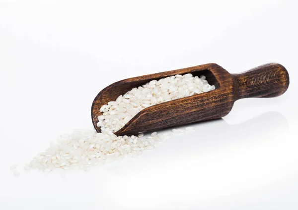 Wooden spoon of raw organic arborio risotto rice on white background. Healthy food. — Stock Photo, Image