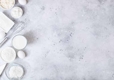Beyaz masa arka planda taze süt ürünleri. Süt, un kase, ekşi krema ve süzme peynir ve yumurta bardak. Çelik çırpıcı. Üst te. Metin için alan